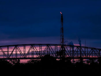 Low angle view of silhouette bridge against sky at dusk