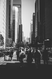 People on street against buildings in city