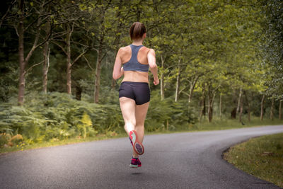 Full length rear view of man running on road