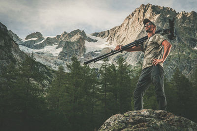 Man standing on rock against mountains