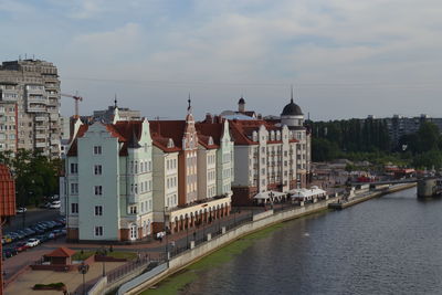 View of town by river against sky