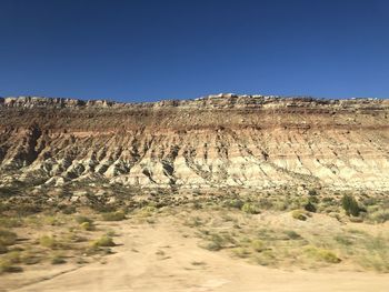 Scenic view of desert against clear blue sky