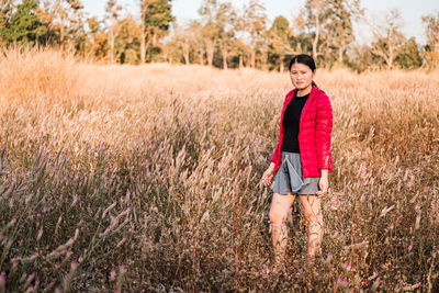 Portrait of smiling young woman standing on field