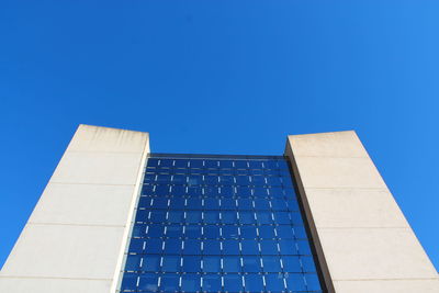 Low angle view of modern building against clear blue sky