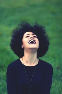 Woman with curly hair laughing outdoors