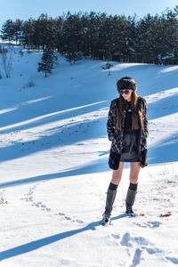 Full length of woman standing on snow covered landscape