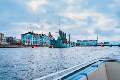 Boats in sea against cloudy sky