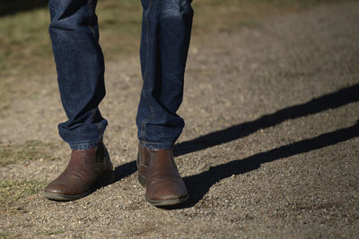 Low section of man wearing shoes standing outdoors