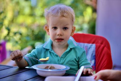 Portrait of boy eating food at home