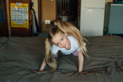 Portrait of a smiling child, listening to music in white headphones, dancing, fooling around at home