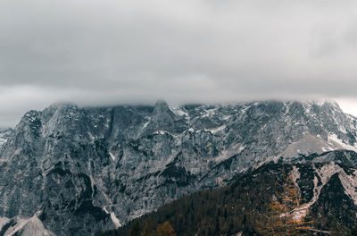 Layer of clouds covering rocky mountain peaks at vrsic mountain pass in julian alps in slovenia