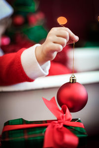 Cropped hand of woman holding christmas decoration