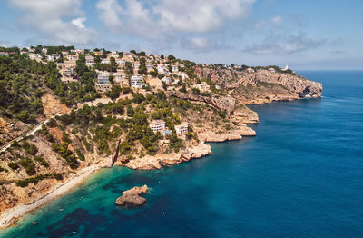 Scenic view of sea by town against sky