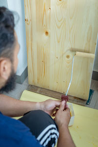 High angle view of man holding hands against wall