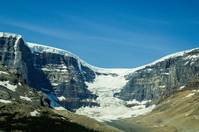 Scenic view of snowcapped mountains against clear blue sky