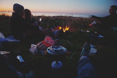 Rear view of people sitting on bonfire