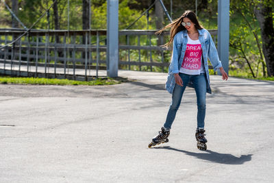 Full length of woman standing on skateboard