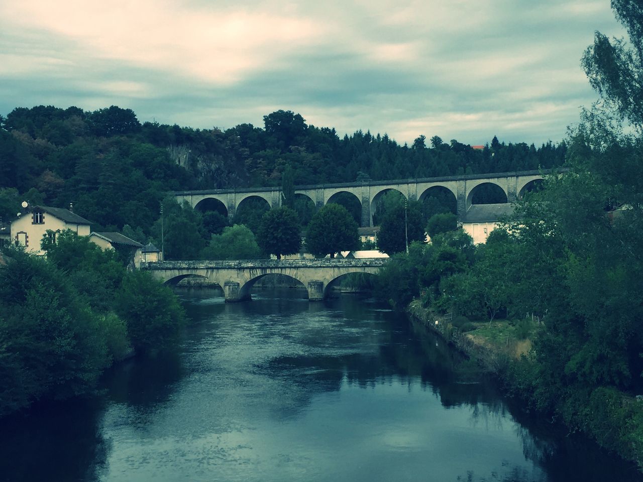 architecture, built structure, tree, water, connection, bridge - man made structure, arch bridge, river, sky, arch, reflection, bridge, waterfront, building exterior, cloud - sky, transportation, nature, canal, tranquility, outdoors