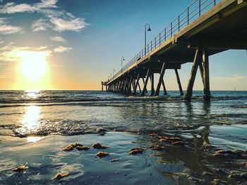 Bridge over sea against sky during sunset