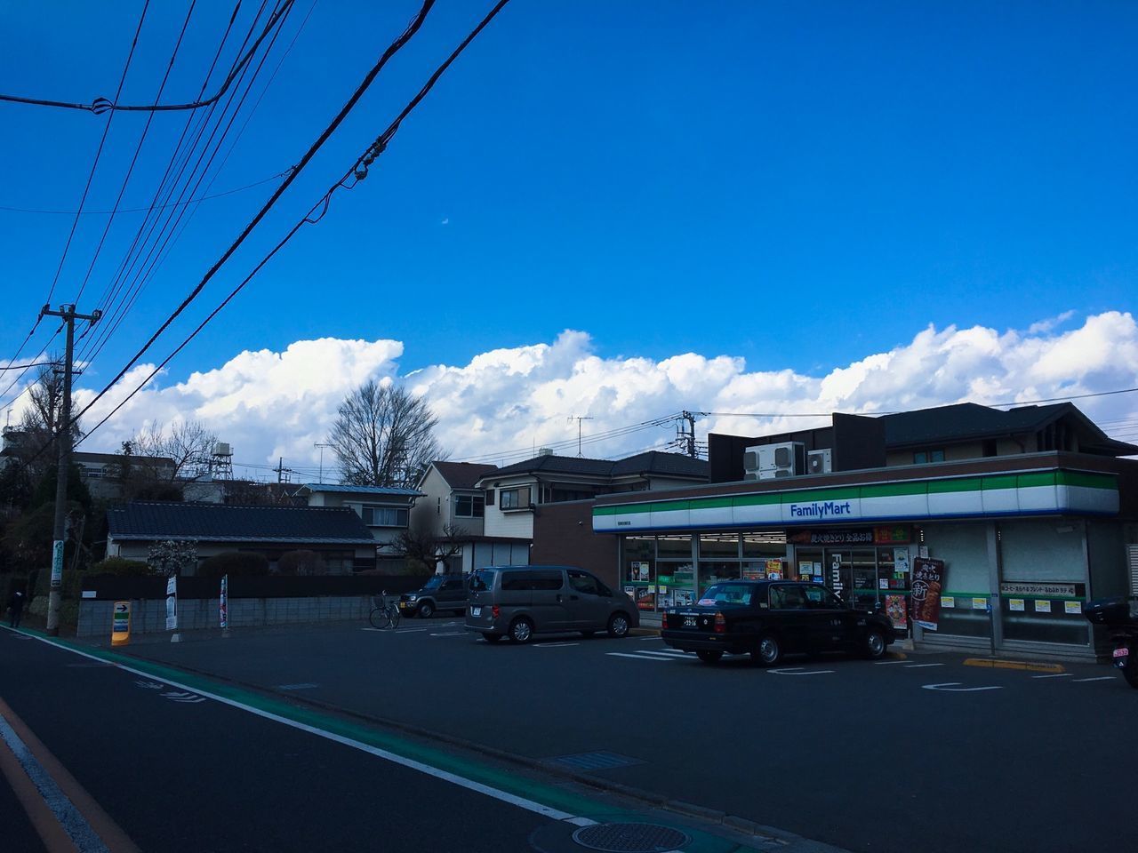 CARS ON ROAD BY BUILDINGS AGAINST SKY