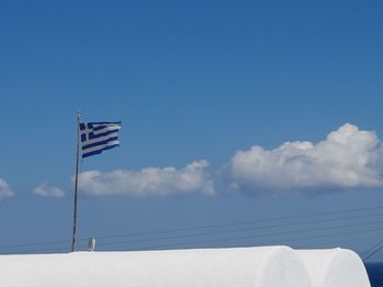 Low angle view of flag against blue sky