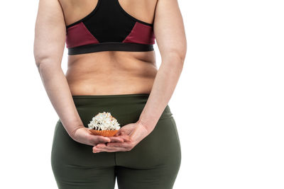 Midsection of woman holding ice cream against white background