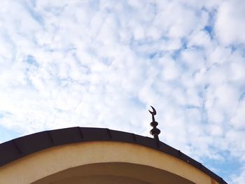 Low angle view of bird on building against sky