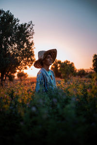 Man wearing hat while standing amidst plants