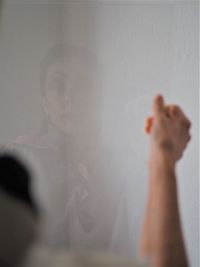 Close-up portrait of hands against wall