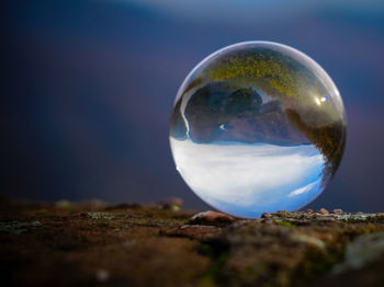 Close-up of crystal ball against sky