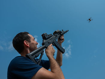 Low angle view of man holding camera