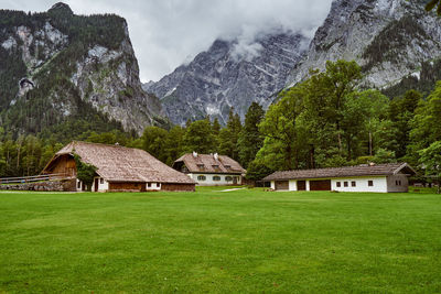Houses by trees and mountains against sky