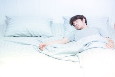 Man sleeping on bed at home