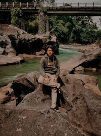 Portrait of man sitting on rock