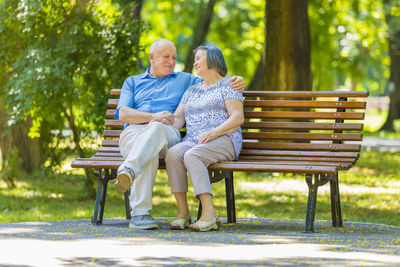 Couple sitting on bench in park