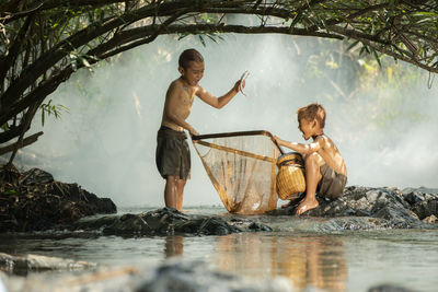 Boys catching fish in lake