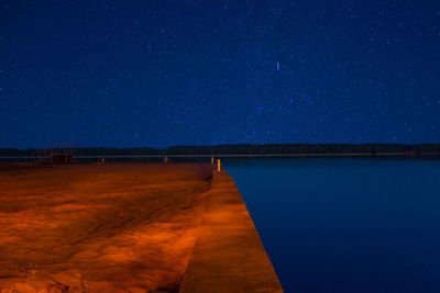 Scenic view of lake against sky at night