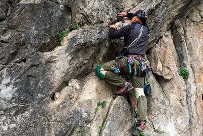 Rear view of man climbing on rock