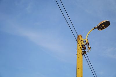 Low angle view of telephone pole against sky