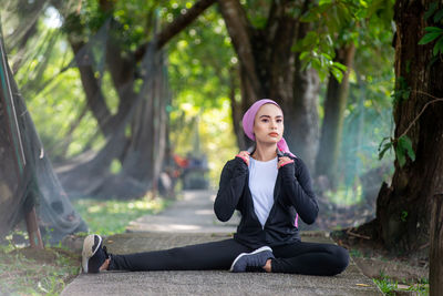 Full length of woman sitting in forest