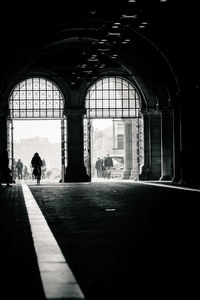 Silhouette people walking in corridor of building