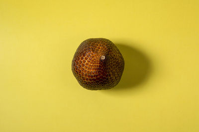 Close-up of snake fruit on yellow background