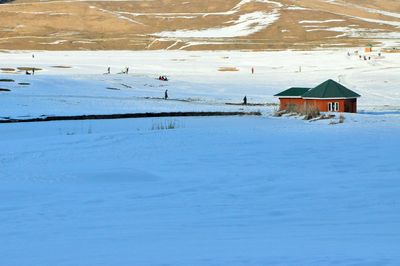 House on snow covered building by mountain