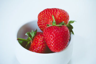 Close-up of strawberries in bowl against white background