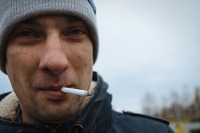 Portrait of man smoking cigarette during winter