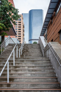 Staircase leading towards city against sky