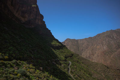 Scenic view of mountains against clear blue sky