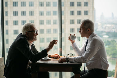 Friends sitting on table by window