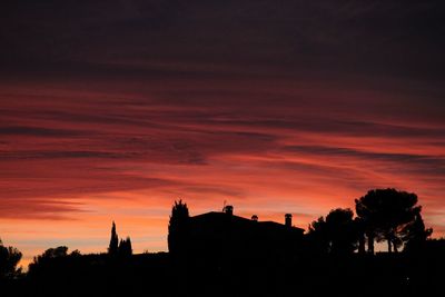 Silhouette trees against sky at sunset