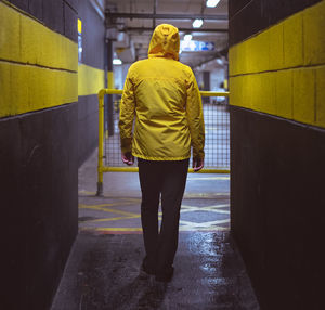 Rear view of woman walking at underground parking lot 